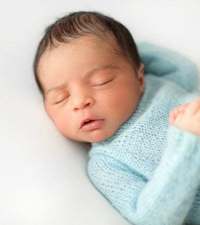 newborn-sleeping-baby-boy-white-chair-cute-blue-crocheted